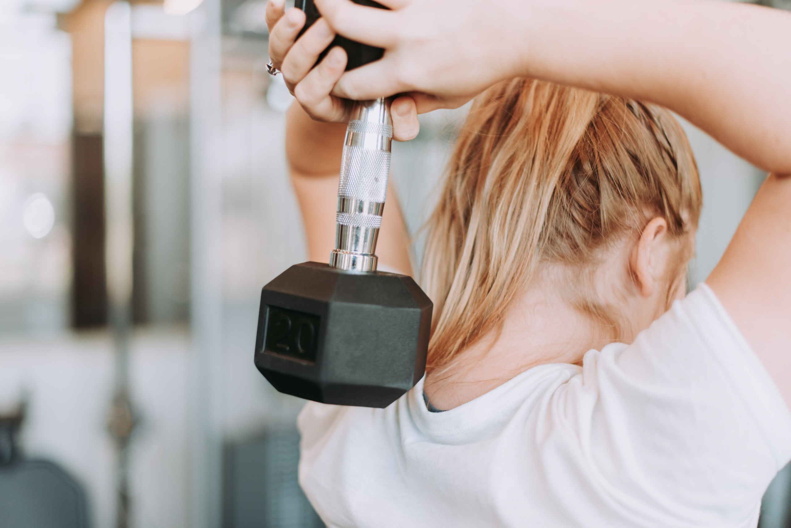 A woman doing an arm work out with a dumb bell