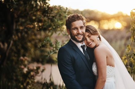 A bride and groom embracing while posing for a photo