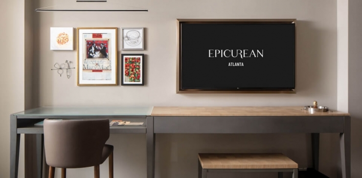 A view of some artwork and a desk in a guest room