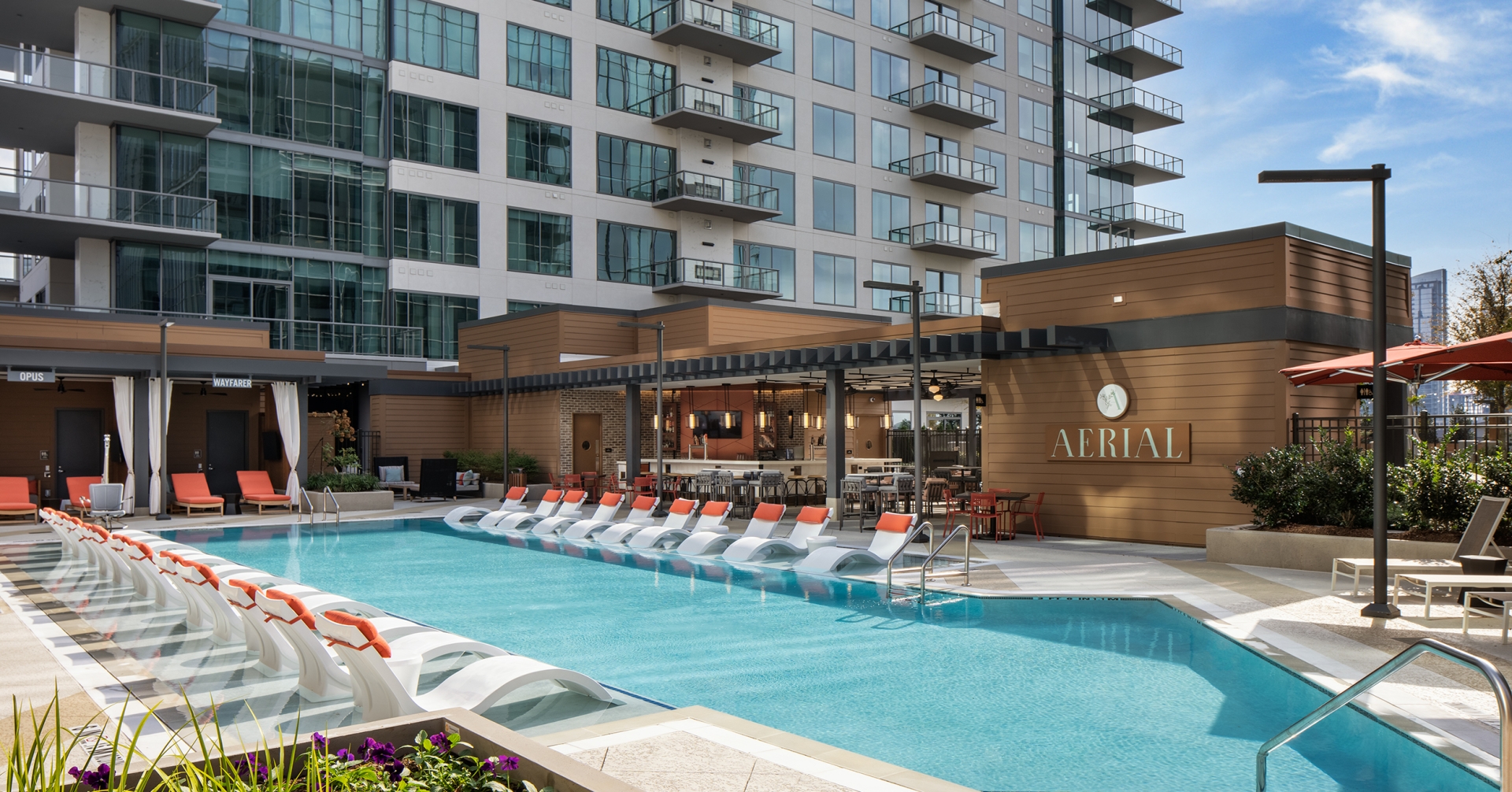 A pool with chairs in front of a building