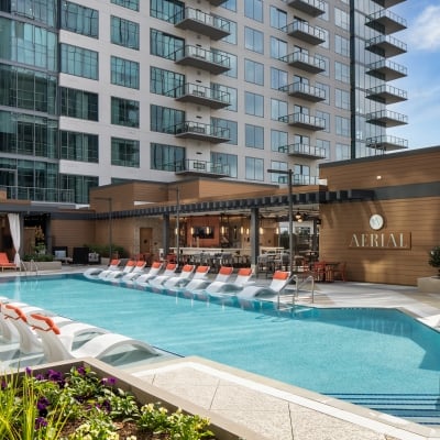A pool with chairs in front of a building