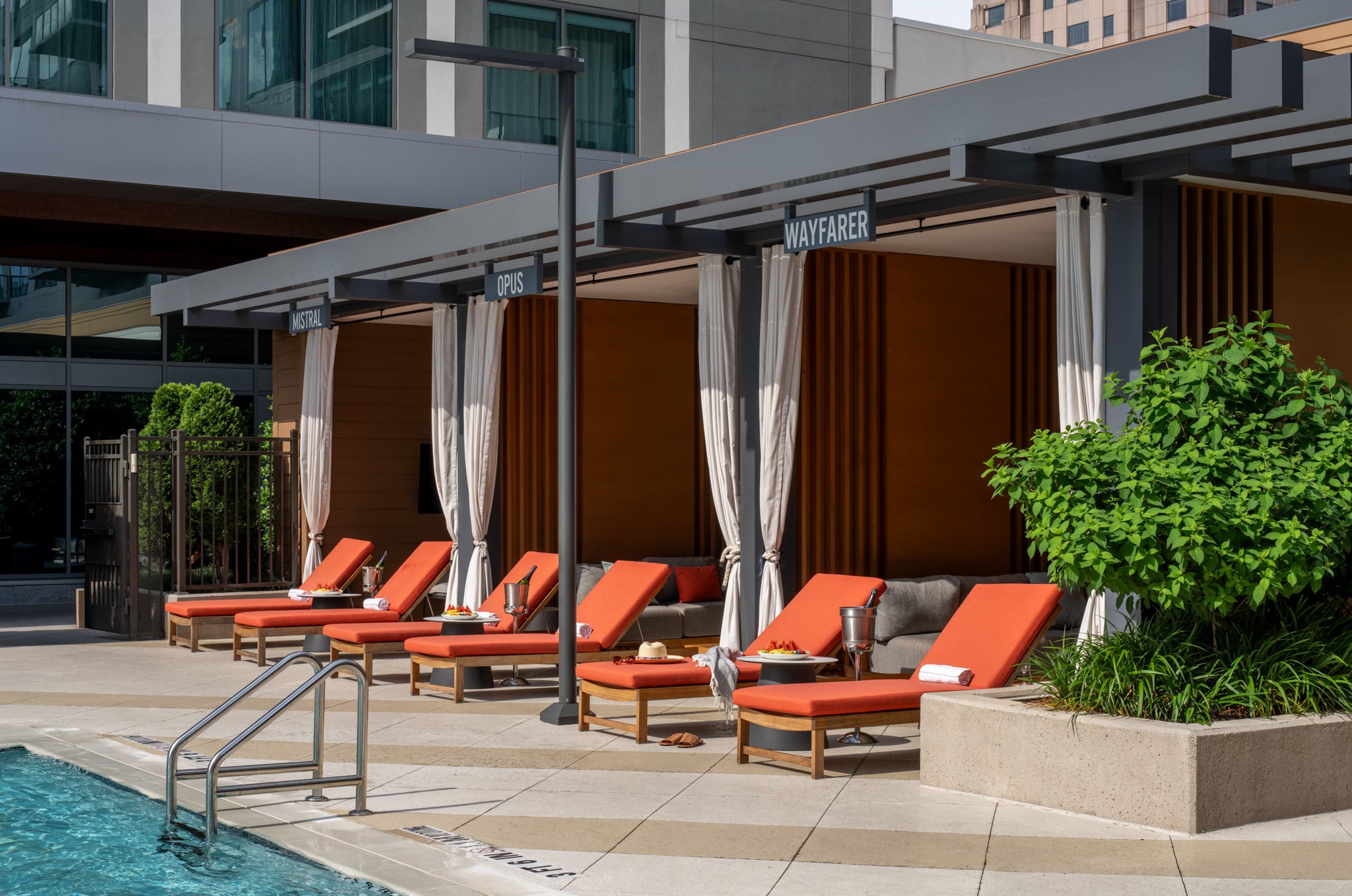 A pool with lounge chairs and a building