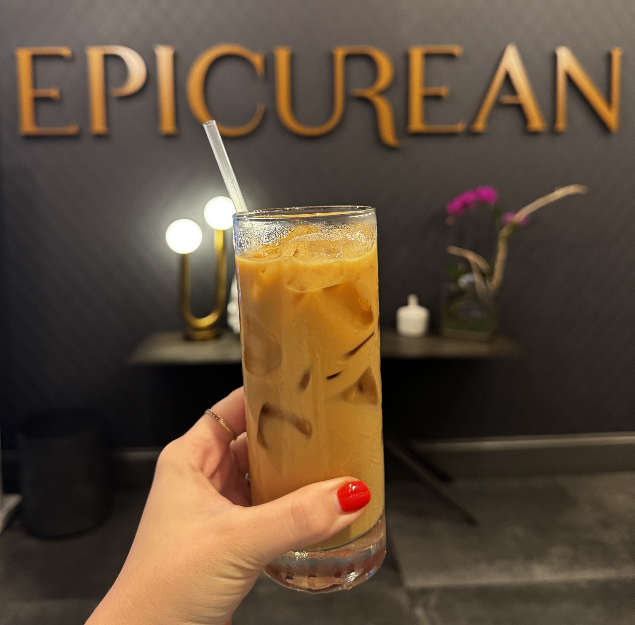 glass of iced cofee in front of Epicurean Atlanta sign